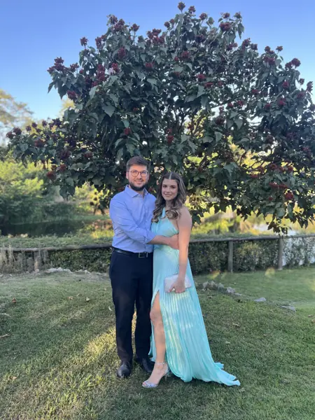 Helena e William em um jardim, vestidos para uma festa