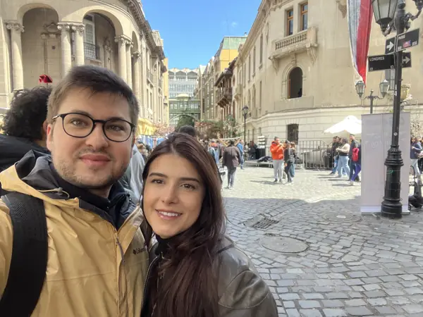 Helena e William em uma rua de prédios históricos