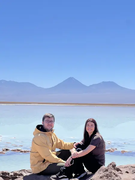 Helena e William sentados diante de uma lagoa