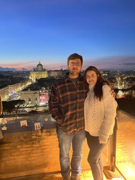 Helena e William em um terraço ao entardecer
