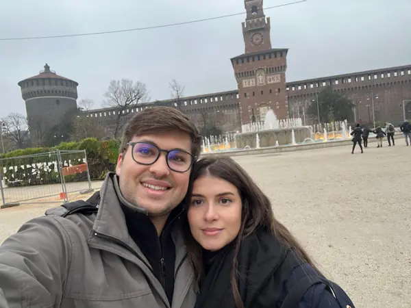Helena e William em uma praça de edifícios históricos